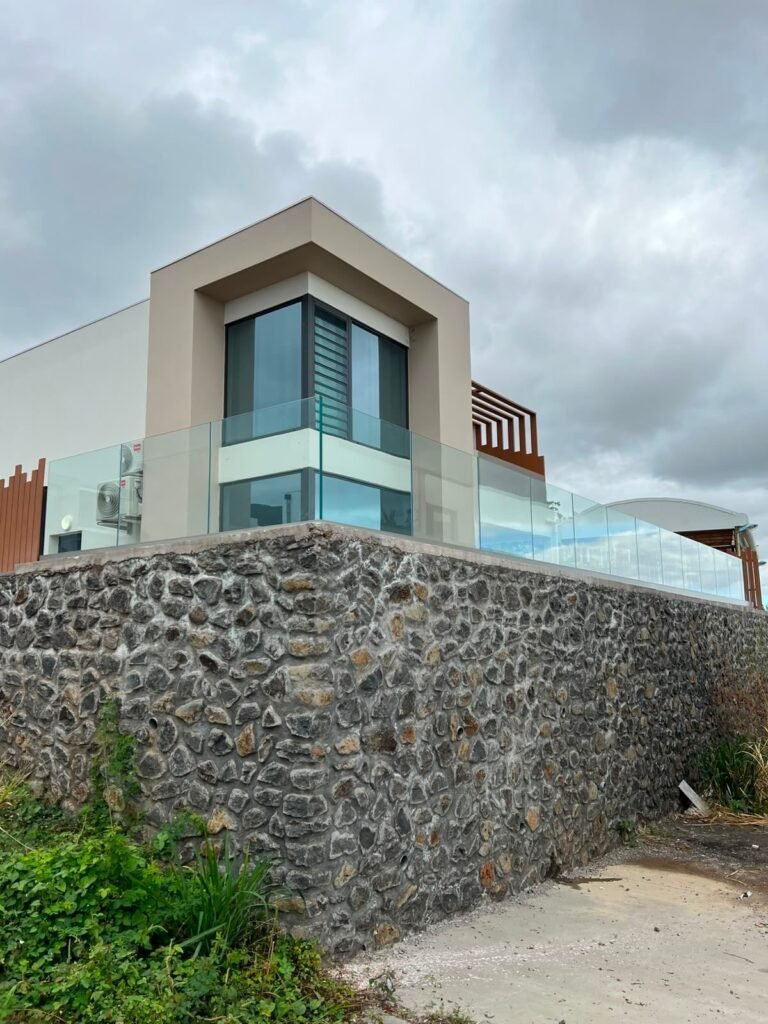 Garde-corps en verre SBalu en bordure d’une terrasse sur mur en pierre