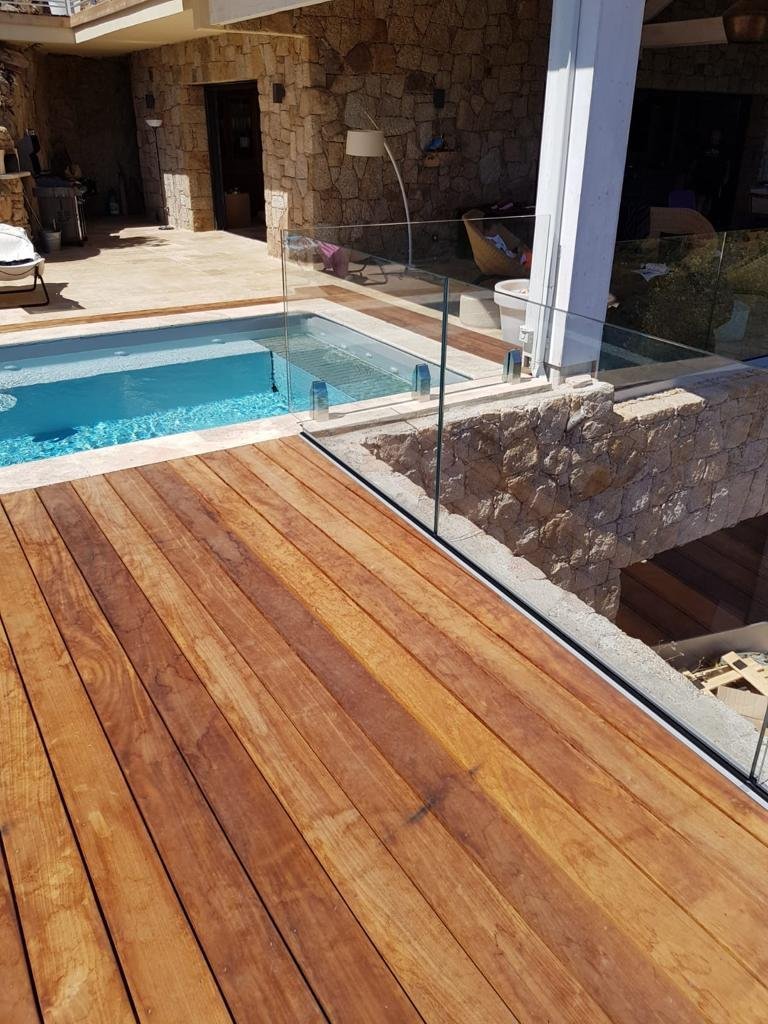 Garde-corps en verre SBalu sur une terrasse en bois au bord d’une piscine